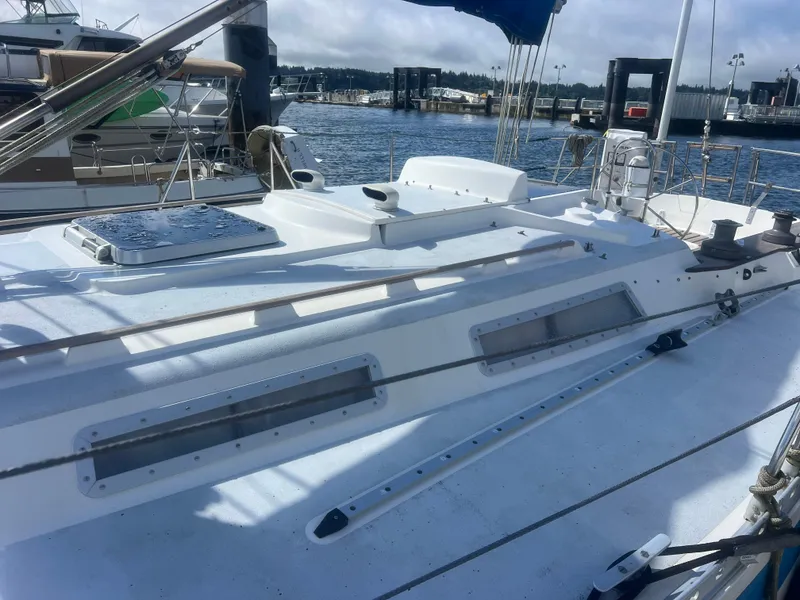 Slide: The Image of 1985 Wauquiez Pretorian Sloop sailboat docked at a marina, showcasing deck and rigging. - 6