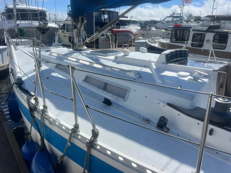 Slide: The Image of 1985 Wauquiez Pretorian Sloop docked in a marina, surrounded by other boats. - 8