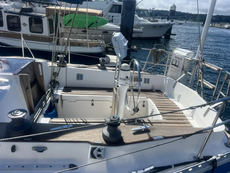 Slide: The Image of 1985 Wauquiez Pretorian Sloop sailboat with wooden deck, docked in a marina. - 9