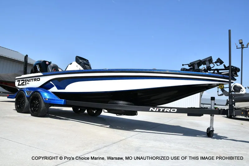Slide: The Image of 2023 Nitro Z21 XL Pro boat on trailer, blue and white design, parked outdoors. - 10