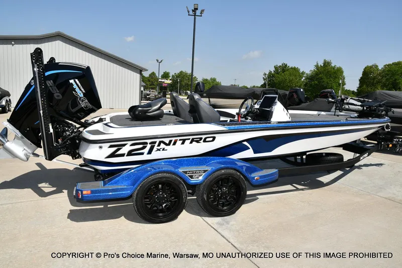 Slide: The Image of 2023 Nitro Z21 XL Pro boat with blue accents on a trailer, parked outdoors. - 22