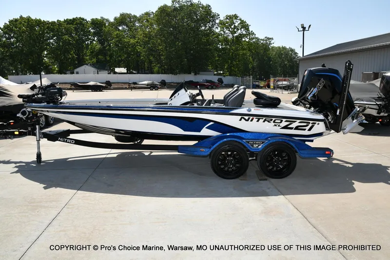 Slide: The Image of 2023 Nitro Z21 XL Pro boat on trailer, blue and white design, parked outdoors. - 29