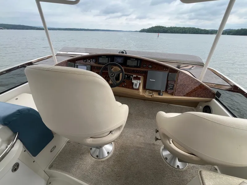 Slide: The Image of Helm of 2004 Marquis 59 yacht with dual seats, overlooking calm waters. - 22