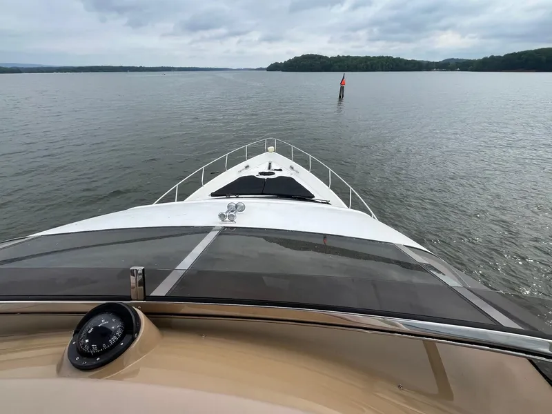 Slide: The Image of Bow view of 2004 Marquis 59 yacht cruising on a calm lake. - 27