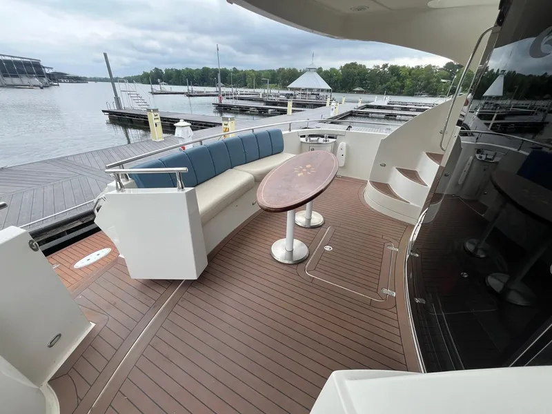 Slide: The Image of 2004 Marquis 59 yacht deck with seating, table, and marina view. - 3