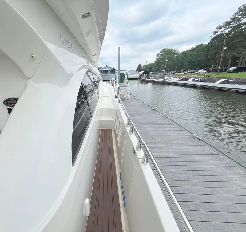 Slide: The Image of Side view of a 2004 Marquis 59 yacht docked at a marina. - 30