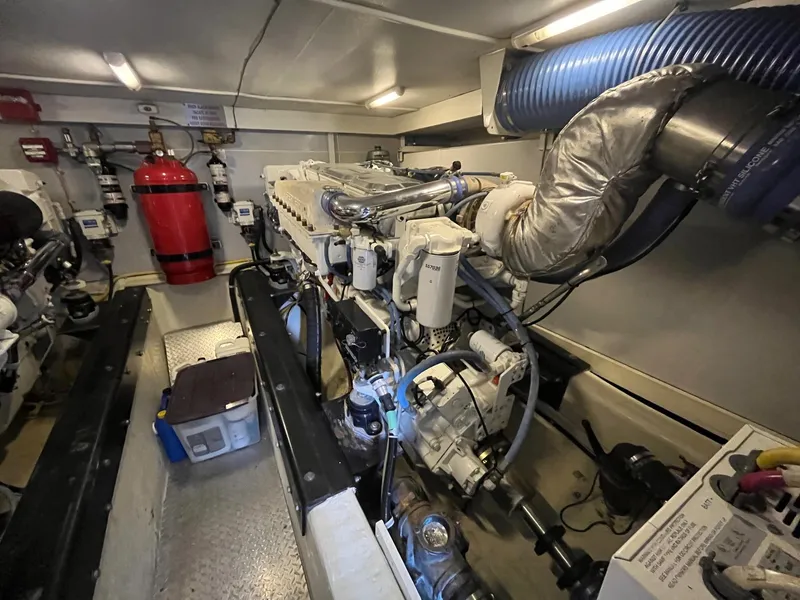 Slide: The Image of Engine room of a 2004 Marquis 59 yacht, featuring mechanical components and fire safety equipment. - 33