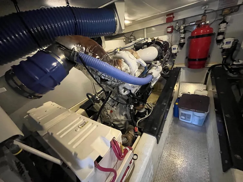 Slide: The Image of Engine room of a 2004 Marquis 59 yacht, featuring complex machinery and equipment. - 34