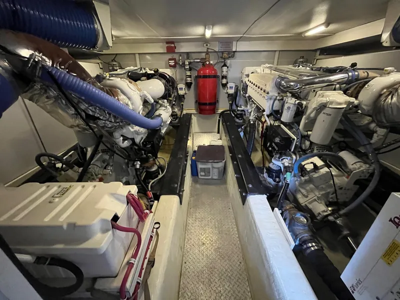 Slide: The Image of Engine room of a 2004 Marquis 59 yacht, featuring dual engines and a fire extinguisher. - 35