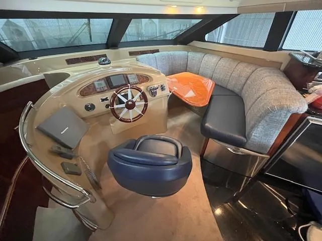 Slide: The Image of Luxurious 2004 Marquis 59 yacht interior with helm, plush seating, and modern controls. - 5