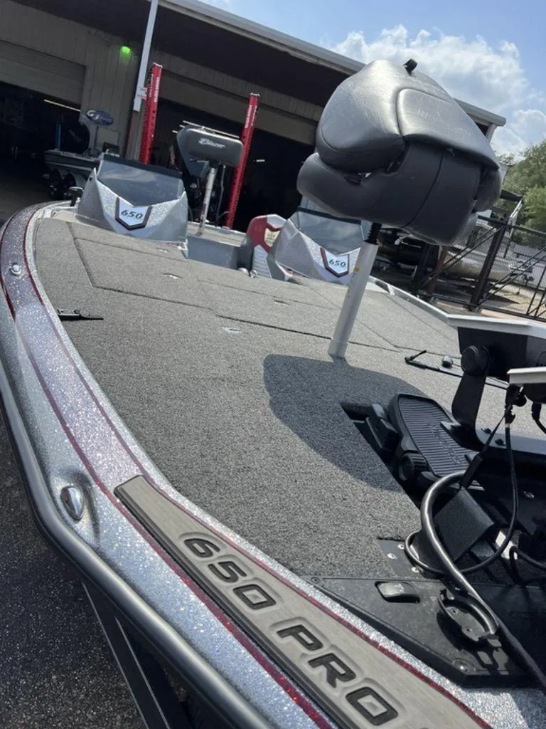 Slide: The Image of 2022 Blazer 650 Pro Tour boat with seating and equipment, parked outdoors. - 42