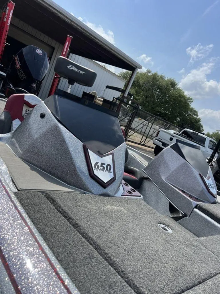 Slide: The Image of 2022 Blazer 650 Pro Tour boat with sleek design, parked outdoors under a clear sky. - 43