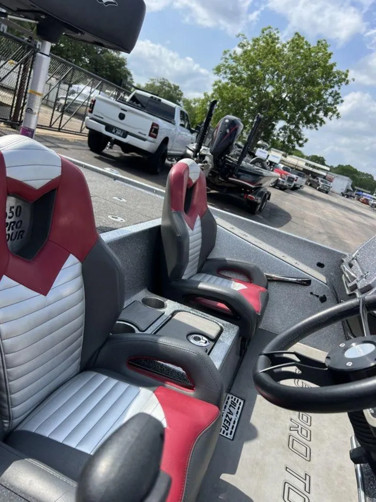 Slide: The Image of 2022 Blazer 650 Pro Tour boat with red and white seats, parked near a white truck. - 46