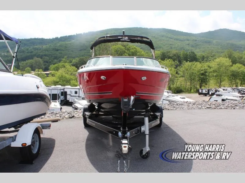 Slide: The Image of 2023 Monterey 224 FS/BR boat in vibrant red, parked on a trailer with scenic mountain backdrop. - 2