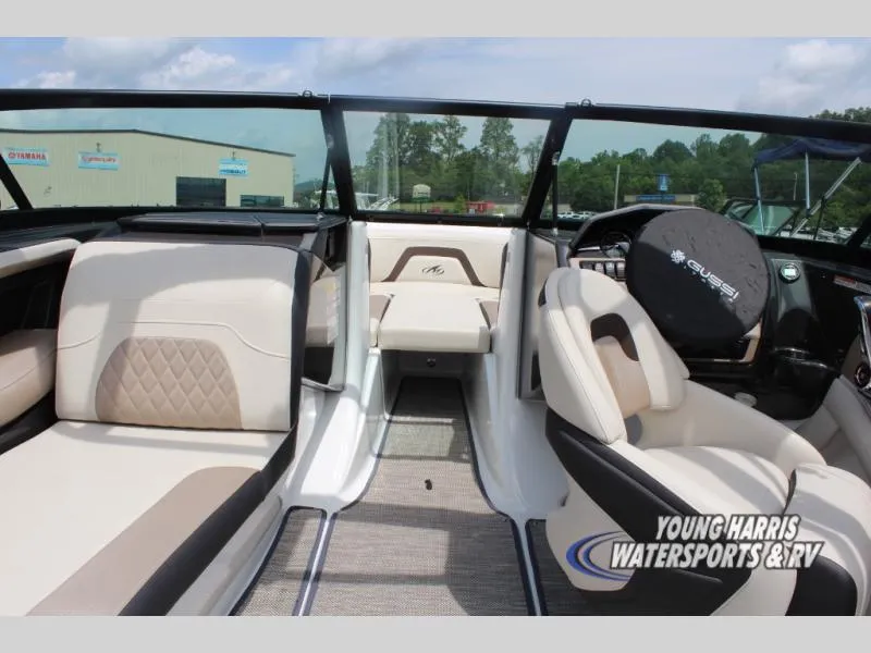 Slide: The Image of 2023 Monterey 224 FS/BR boat interior with beige seating and steering wheel cover. - 7