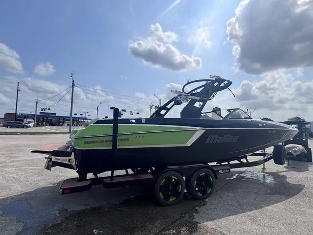 Slide: The Image of 2018 Malibu 24 MXZ boat on trailer under cloudy sky. - 10