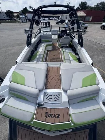 Slide: The Image of 2018 Malibu 24 MXZ boat with green and white interior, docked outdoors. - 12