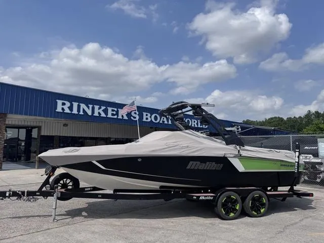 Slide: The Image of 2018 Malibu 24 MXZ boat covered on trailer at Rinker's Boat World dealership. - 15