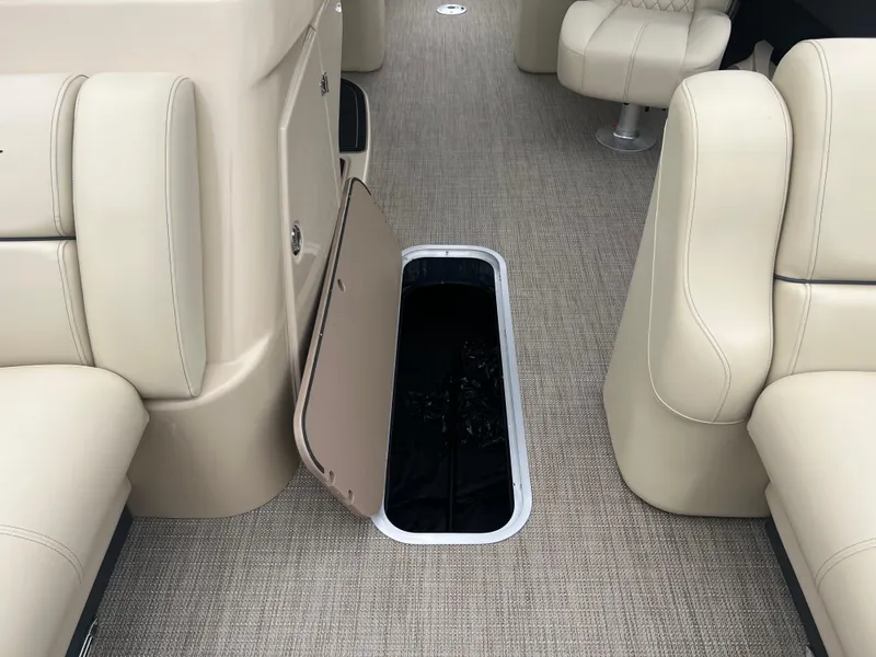 Slide: The Image of 2025 Starcraft RX 23 R DC boat interior with open storage compartment and beige seating. - 12