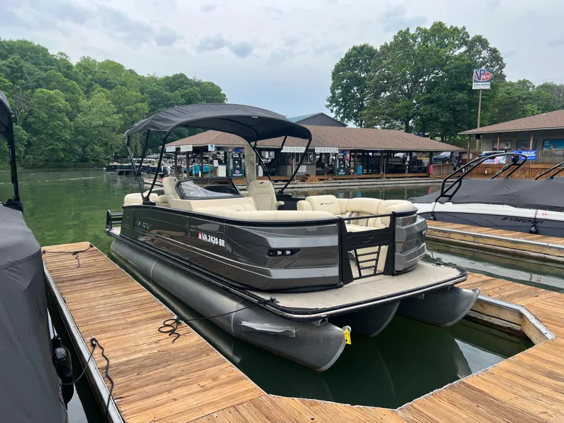 Slide: The Image of 2025 Starcraft RX 23 R DC pontoon boat docked on a serene lake. - 3