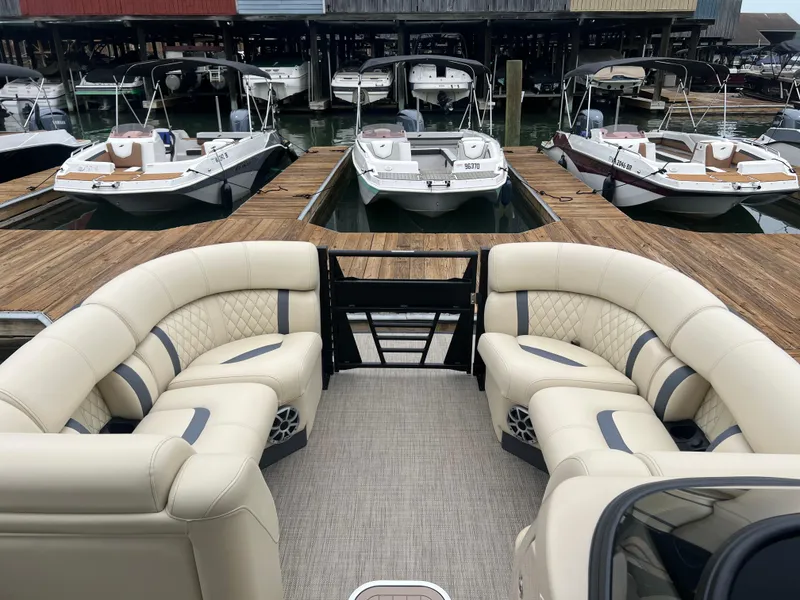 Slide: The Image of 2025 Starcraft RX 23 R DC boat with luxurious seating at a marina dock. - 5