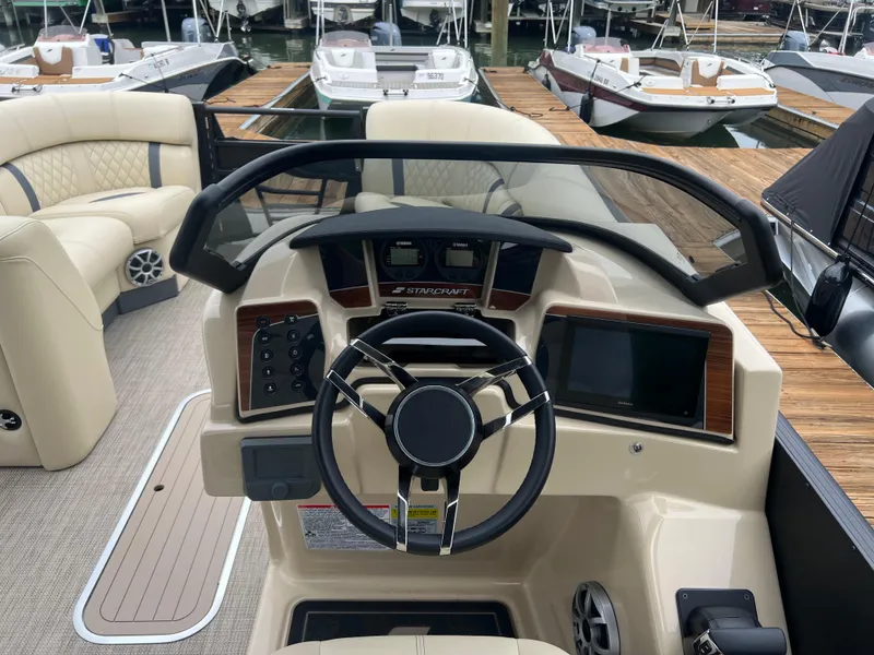 Slide: The Image of 2025 Starcraft RX 23 R DC boat dashboard with steering wheel and control panel. - 7