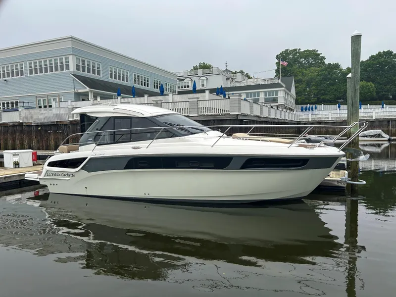 The Image of 2017 Bavaria S36 Coupe docked at a marina, with modern architecture in the background. - 0