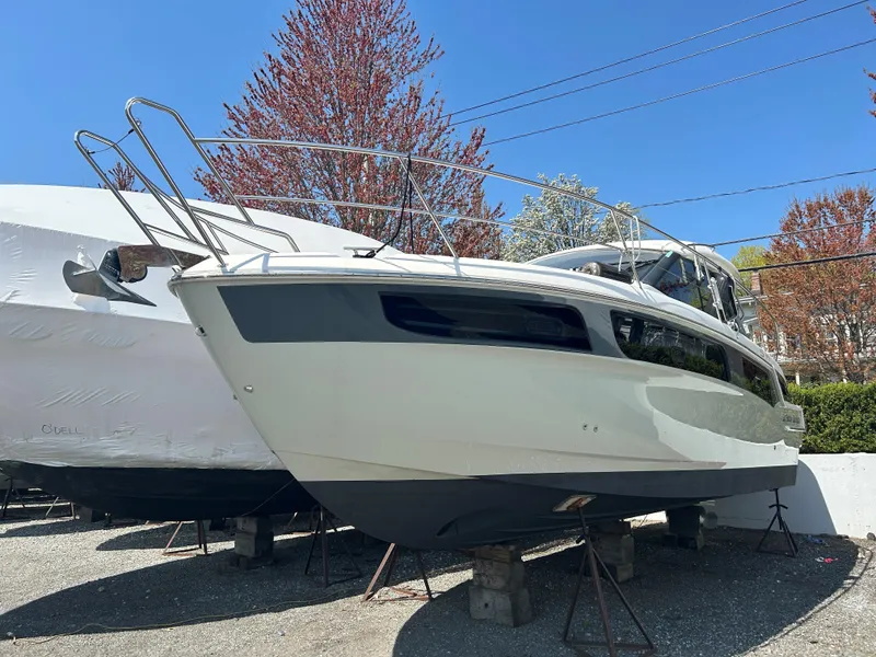 Slide: The Image of 2017 Bavaria S36 Coupe boat on stands, surrounded by trees and clear blue sky. - 13