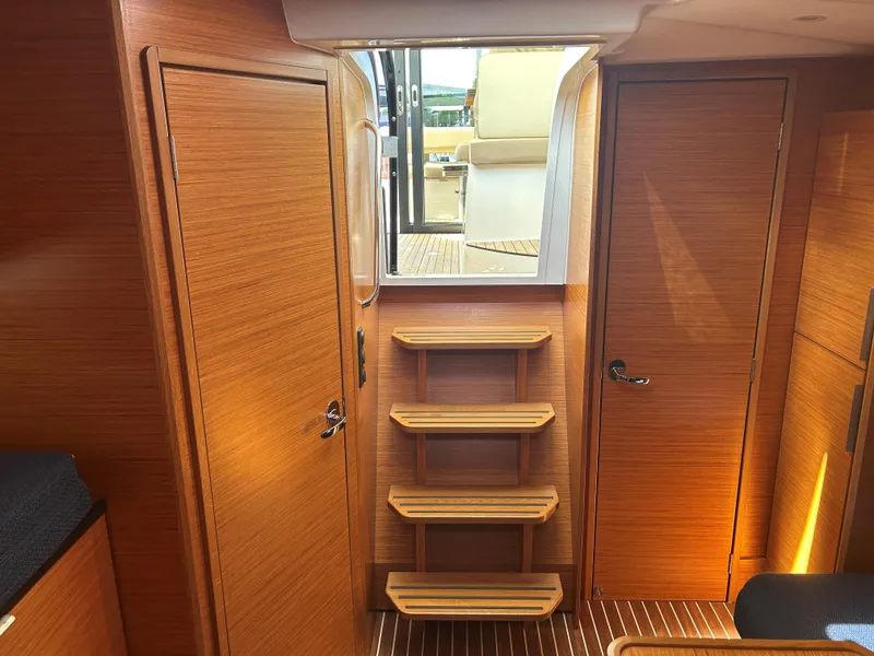 Slide: The Image of Interior of 2017 Bavaria S36 Coupe yacht with wooden finish and steps leading outside. - 20
