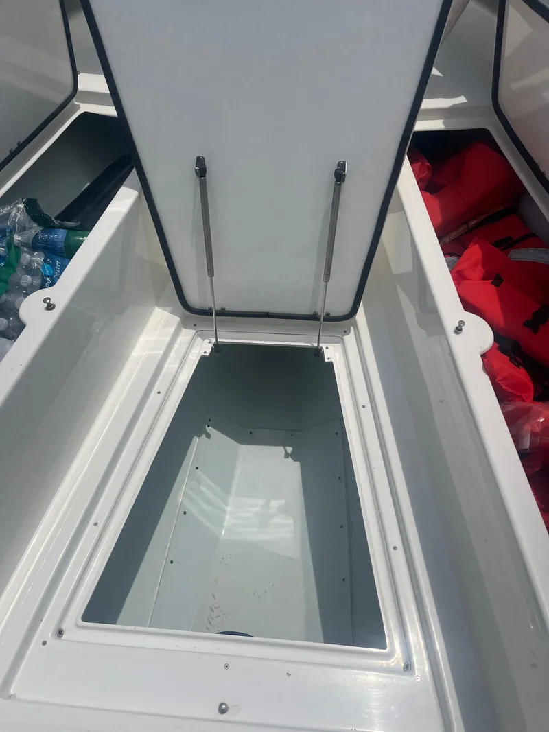 Slide: The Image of 2016 Venture 39 Forward Seating boat storage compartment with open hatch and visible life jackets. - 14