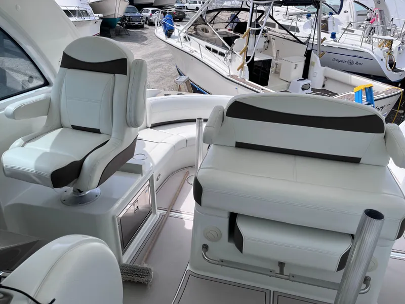 Slide: The Image of 2009 Cruisers Yachts 390 Sports Coupe interior with white seating in a marina setting. - 8
