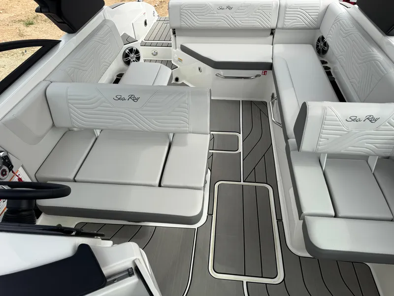 Slide: The Image of 2025 Sea Ray SDX 270 Surf boat interior with white seating and gray flooring. - 10