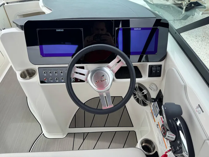 Slide: The Image of 2025 Sea Ray SDX 270 Surf boat dashboard with steering wheel and dual displays. - 14