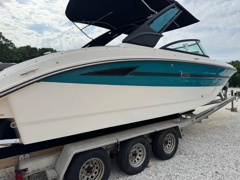 Slide: The Image of 2025 Sea Ray SDX 270 Surf boat on trailer, featuring sleek design and vibrant teal accents. - 2