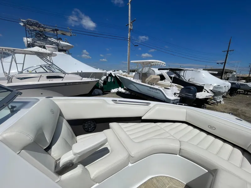 Slide: The Image of 2016 Cobalt R5 boat with white interior, docked among other boats under a clear blue sky. - 10