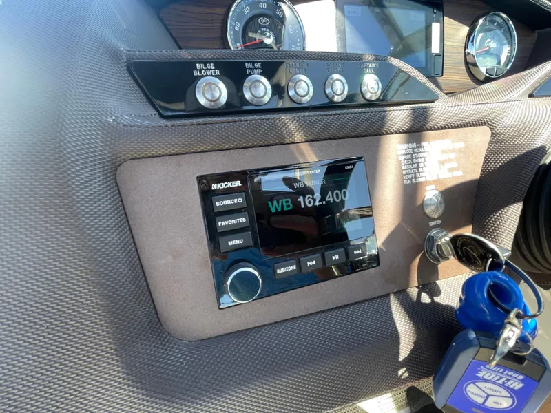 Slide: The Image of Dashboard of a 2016 Cobalt R5 boat featuring a Kicker audio system and controls. - 20