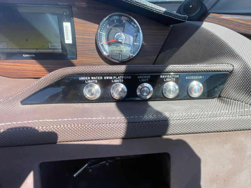 Slide: The Image of Dashboard controls of a 2016 Cobalt R5 boat with various light switches. - 22