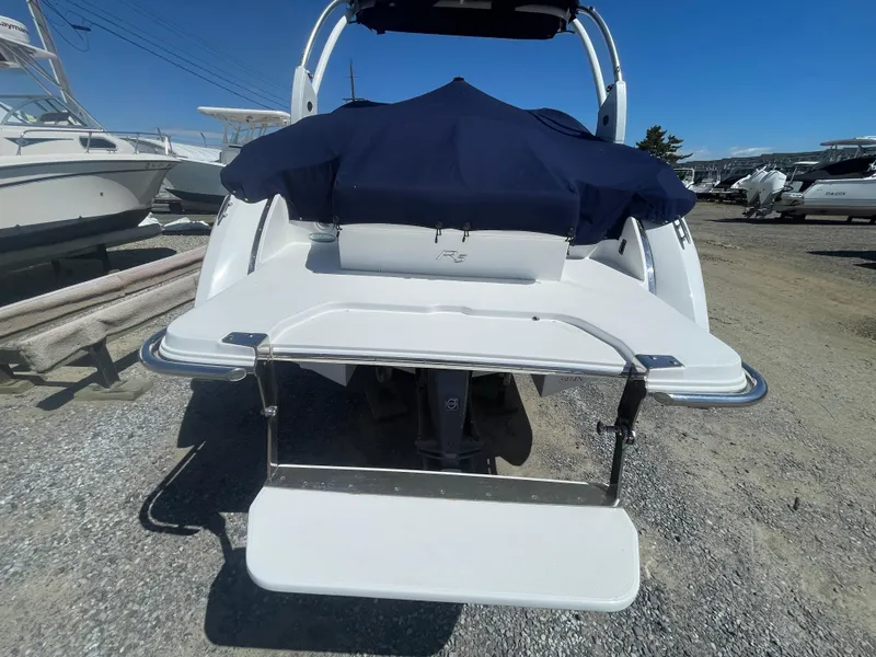 Slide: The Image of 2016 Cobalt R5 boat rear view with swim platform, parked on gravel. - 7