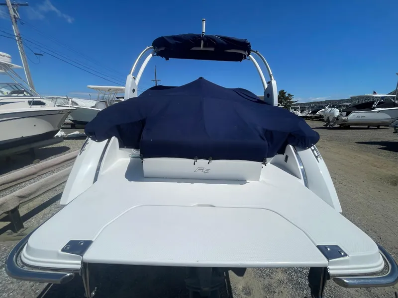 Slide: The Image of 2016 Cobalt R5 boat with blue cover, parked on gravel lot under clear sky. - 8