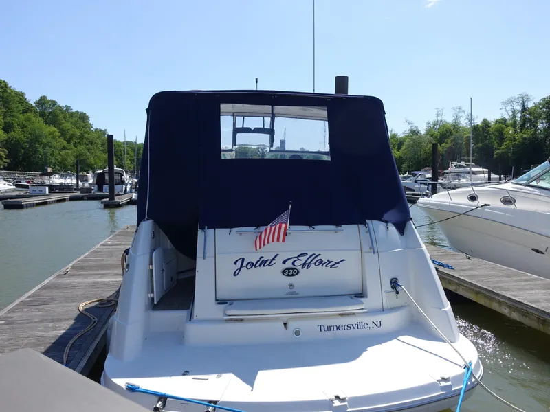 Slide: The Image of 2008 Rinker 330 Express Cruiser docked at marina, rear view with American flag. - 1