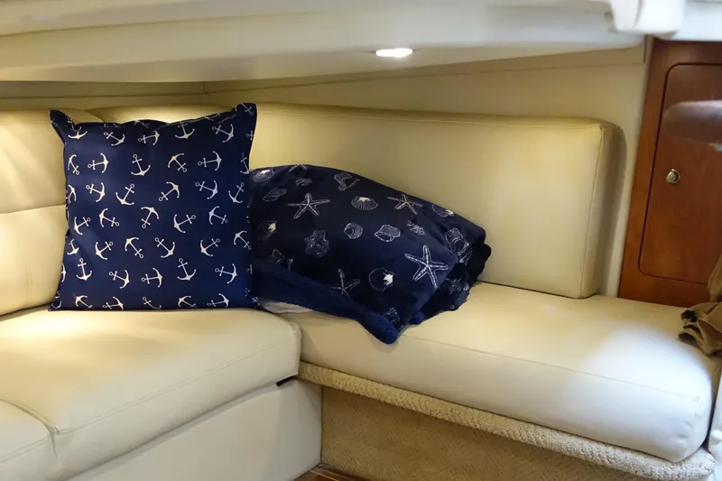 Slide: The Image of 2008 Rinker 330 Express Cruiser interior with nautical-themed cushions on a cream sofa. - 14