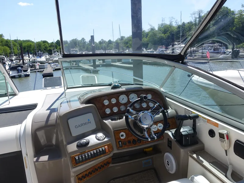 Slide: The Image of 2008 Rinker 330 Express Cruiser helm with Garmin navigation, docked at a marina. - 17
