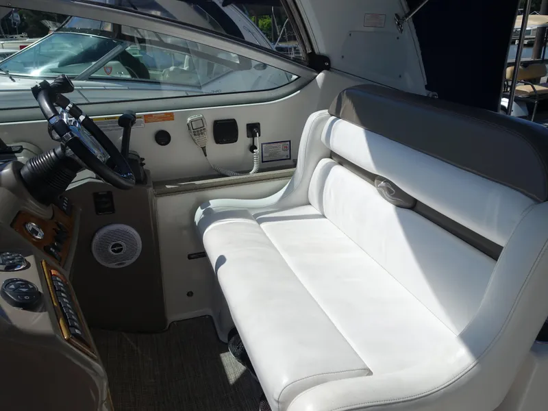 Slide: The Image of 2008 Rinker 330 Express Cruiser interior with white seating and control panel. - 19