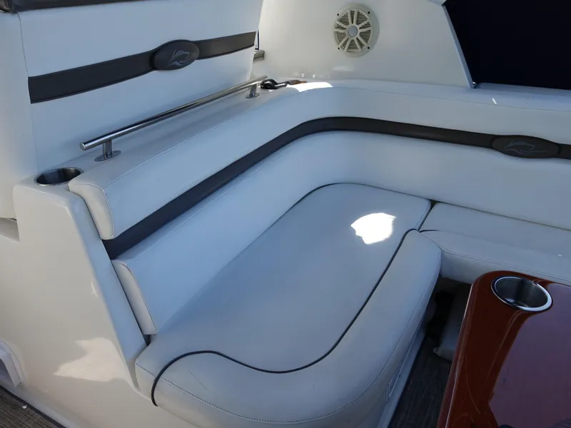 Slide: The Image of 2008 Rinker 330 Express Cruiser interior seating with white upholstery and cup holder. - 20