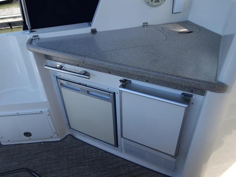 Slide: The Image of 2008 Rinker 330 Express Cruiser kitchenette with countertop and built-in appliances. - 21