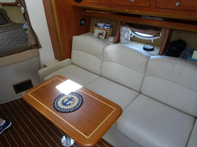 Slide: The Image of Interior of 2008 Rinker 330 Express Cruiser with white sofa and wooden table. - 3