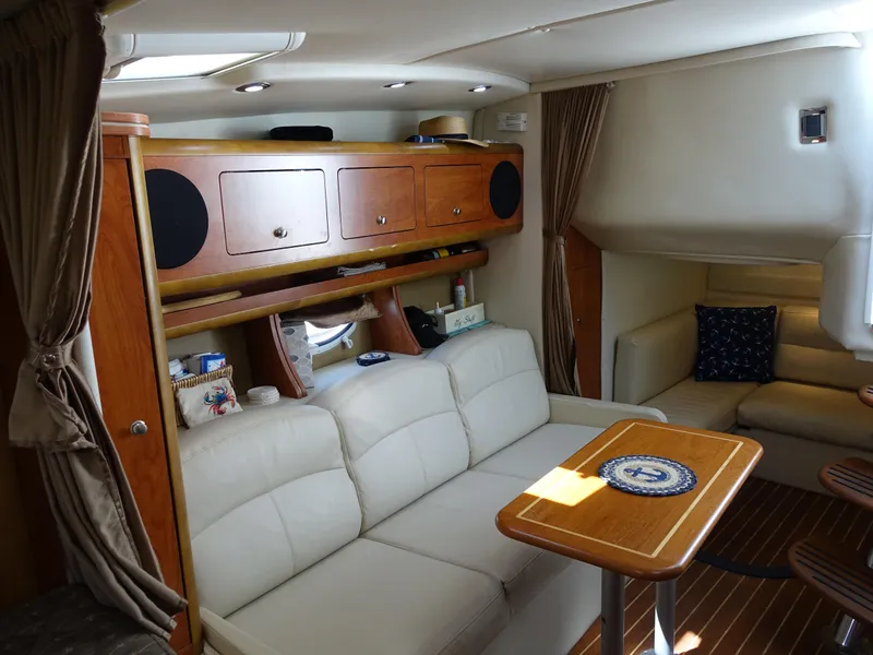 Slide: The Image of 2008 Rinker 330 Express Cruiser interior with white seating and wooden cabinetry. - 5