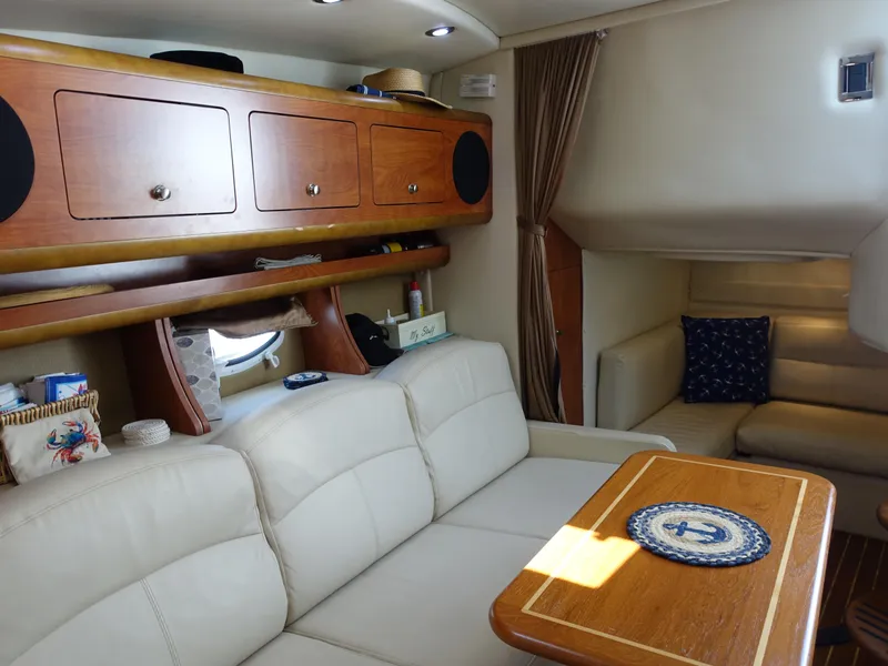 Slide: The Image of Interior of 2008 Rinker 330 Express Cruiser with beige seating and wooden cabinetry. - 8