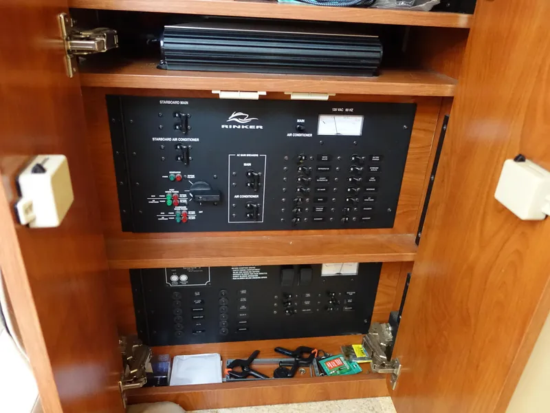 Slide: The Image of Electrical panel inside 2008 Rinker 330 Express Cruiser, featuring switches and storage compartments. - 9