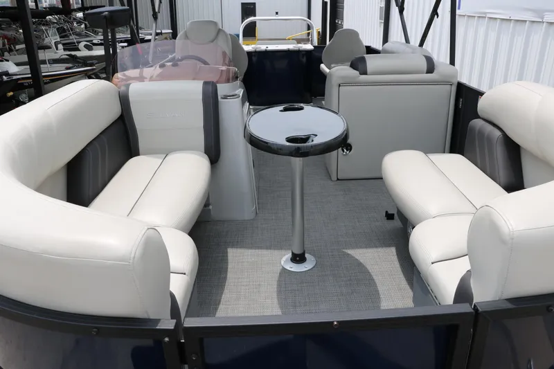 Slide: The Image of 2023 Sylvan Mirage Fish 820 Party Fish boat interior with plush seating and central table. - 13
